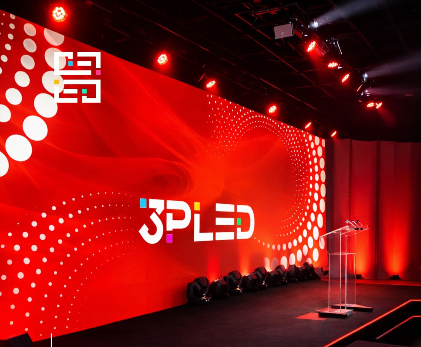 Telão de LED modular montado em palco de evento com público em silhueta