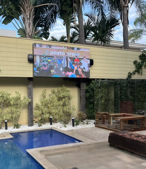 Fachada comercial com faixa de painel de LED acesa acima da entrada da loja